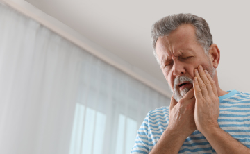 歯の痛みを感じた男性の写真