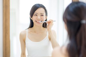 女性が歯周病予防のため歯磨きをしている写真