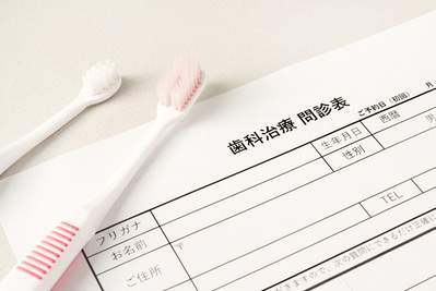 麻布十番の歯医者さんで受ける問診票と歯ブラシのイメージ写真