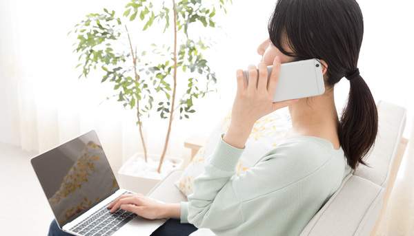 麻布十番の歯医者さんの予約状況を確認し電話で予約を取る女性の写真